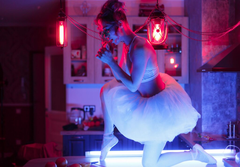 Playful editorial boudoir photography in a Las Vegas kitchen featuring a model in a white tutu and sunglasses